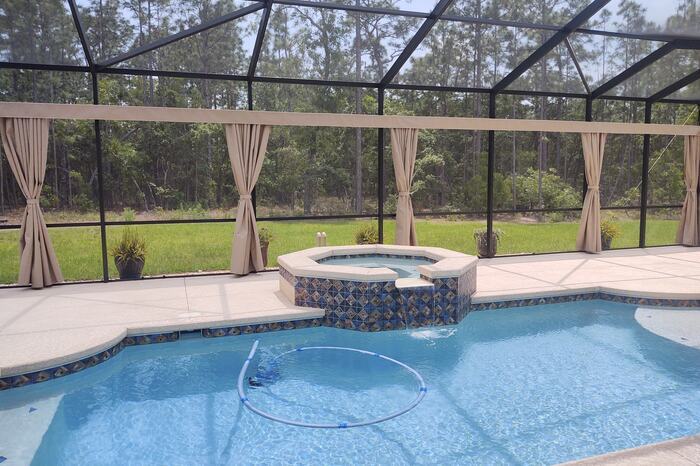 Screened pool and spa with a preserve view in Suntree, FL